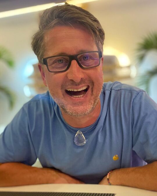 Michael Danner, lachend an einem Tisch sitzend